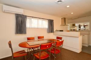 a kitchen and dining room with a table and chairs at Dukes Midway Lodge in Auckland