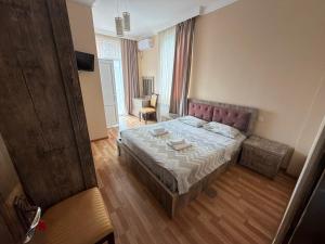 a bedroom with a bed and a chair in it at Hotel Like Mari in P'ichvnari