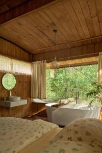 a bedroom with a tub and a bed and a window at Dreaming Retreat Da Lat in Ấp An Kroët