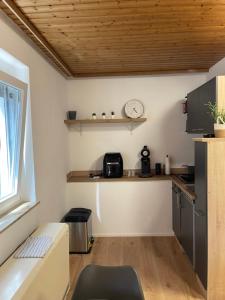 a kitchen with a counter and a clock on the wall at Garten Oase Weisweil in Weisweil