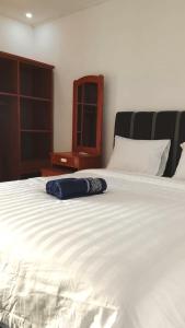 a large white bed with a blue pillow on it at USTIN Villas Lombok in Bumbang