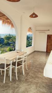 a dining room with a wooden table and chairs at USTIN Villas Lombok in Bumbang