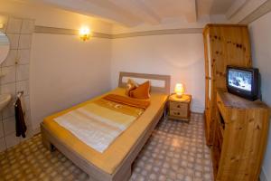 niewielka sypialnia z łóżkiem i telewizorem w obiekcie Lindenschänke w mieście Werl