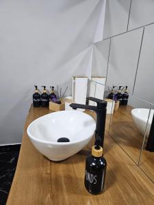 a bathroom with a white bowl sink and a bottle of soap at Casuța din Colți in Colţi