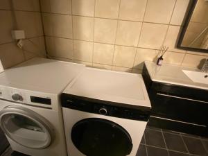 a small bathroom with a washing machine and a sink at Cozy & Private House in Roslev