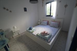 a small bedroom with a bed with a window at Sofia's house in Possidi
