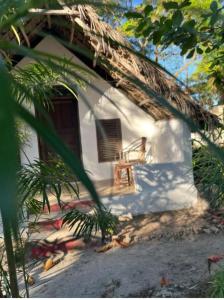 a white house with a chair on the porch at Warembo beach Nungwi in Nungwi