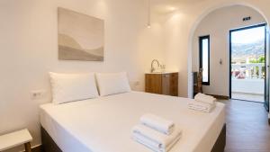 a bedroom with a white bed with towels on it at Ela Mare Sea View Apartments in Malia