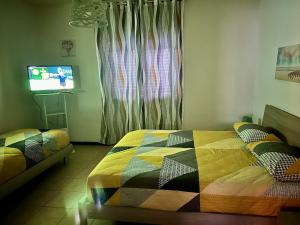 a bedroom with a bed and a tv in it at La Farfalla B&B - Mark&Rosy in Malonno