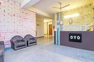 a lobby with two chairs against a brick wall at Hotel O Honey Inn in New Delhi
