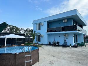 a blue house with a swimming pool in front of it at Sunset paradise in Ureki
