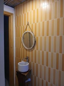 a bathroom with a mirror on a tiled wall at Te Retreat in Hà My Tây (2)