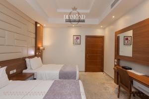 a hotel room with two beds and a desk at Diamond Tower Hotel in Jeddah +55 photos