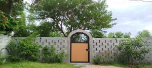 a brick fence with a door in a yard at Te Retreat in Hà My Tây (2) +2 photos
