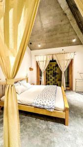 a bedroom with a large bed with a curtain at Te Retreat in Hà My Tây (2)