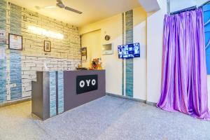 a room with a tv and purple curtains at Hotel O Honey Inn in New Delhi