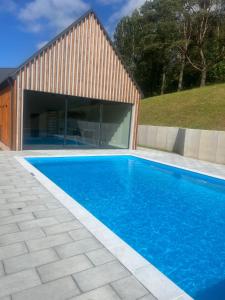 a swimming pool in front of a house at Willa 27P Aura Kaszub in Łączyno
