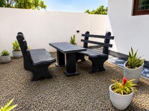a picnic table and a bench and potted plants at Blue Waves Ocean Mirissa in Mirissa