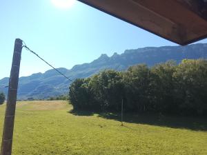 a view of a field with mountains in the background at Chambre Tarentaise chez les garçons in Saint-Paul-sur-Yenne