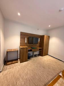 a room with a desk and a tv on a wall at Johra International Hotel فندق جوهرة إنتر ناشونال in Medina