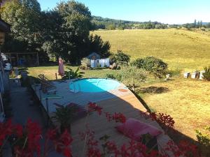 a woman standing next to a swimming pool in a yard at Chambre Tarentaise chez les garçons in Saint-Paul-sur-Yenne