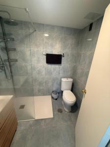 a bathroom with a toilet and a glass shower at torremolinos centro parking privado in Torremolinos +3 photos