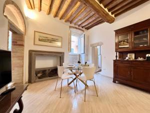 a dining room with a table and chairs and a fireplace at Pinturicchio Luxury Suite in Perugia