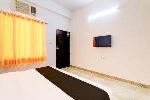 a bedroom with a bed and a television on the wall at Hotel O Samar palace in Lucknow