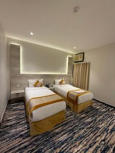 a hotel room with two beds in a room at Johra International Hotel فندق جوهرة إنتر ناشونال in Medina +15 photos