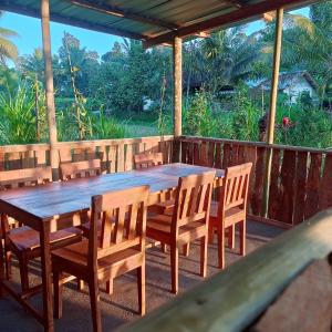 a wooden table and chairs on a deck at Nahla bungalows tetebatu in Tetebatu