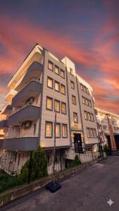 a large white building with a sunset in the background at Gür Apartment in Trabzon