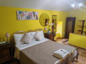 a bedroom with a large bed with yellow walls at Il Rifugio Rosa in Anagni