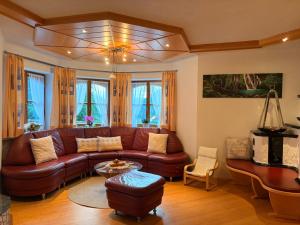 a living room with a brown leather couch and a table at Ferienhaus Sophia & Ilse in Murau