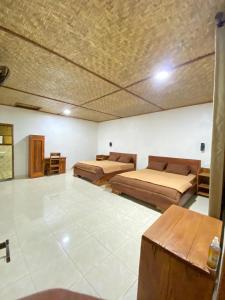 a large room with two beds and a table at Nahla bungalows tetebatu in Tetebatu