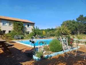 a swimming pool in front of a villa at Bel Hotel Restaurant la Gentilhommière in Trèbes