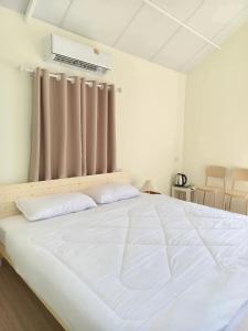 a large white bed in a room with a window at บ้านตัวเล็กศาลายา in Sathani Wat Suwan