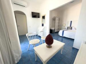 a room with a bed and a table and chairs at Hotel Chiaia Di Luna in Ponza