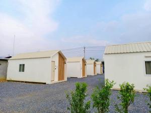 a row of white buildings in a parking lot at บ้านตัวเล็กศาลายา in Sathani Wat Suwan