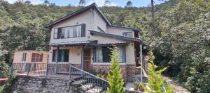 a house on the side of a hill with trees at Fursat Exclusive Solitude in Rāmgarh +23 photos