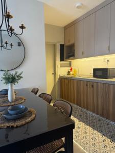 a kitchen with a table and some chairs and a counter at Rumah Suri Homestay at Arena2 Residence Kota Warisan in Sepang