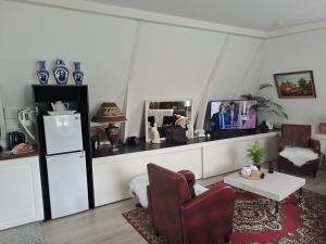 a living room with a refrigerator and a red chair at Het Speijerhuis in Harlingen +12 photos