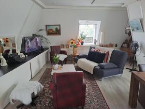 a living room with a couch and chairs and a table at Het Speijerhuis in Harlingen