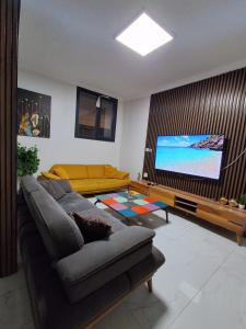 a living room with a couch and a flat screen tv at Kasabalı OTEL&BUNGALOW in Bulgurca
