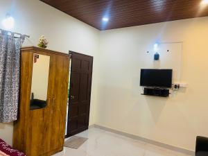 a room with a door and a tv on the wall at Skyview homestay Devaramane in Mudigere +14 photos