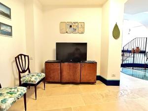a living room with a tv and a chair at Circumpiso in Massa Lubrense