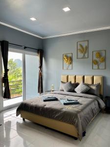 a bedroom with a large bed and a large window at Khaosok Diary Camp in Khao Sok National Park