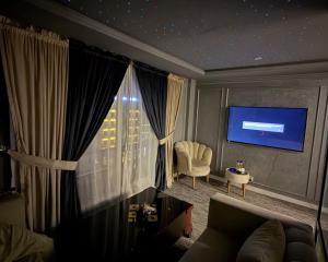 a living room with a couch and a tv at premium category 2 bedrooms apartment in Lahore