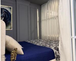 a bedroom with a bed with blue sheets and a window at premium category 2 bedrooms apartment in Lahore