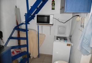 a kitchen with a microwave on a shelf with a refrigerator at Nagos Home in Nagós