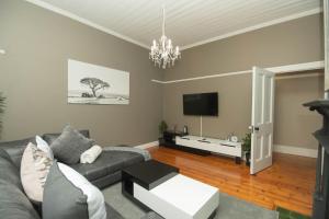 a living room with a couch and a tv at Crown Oak in Gqeberha